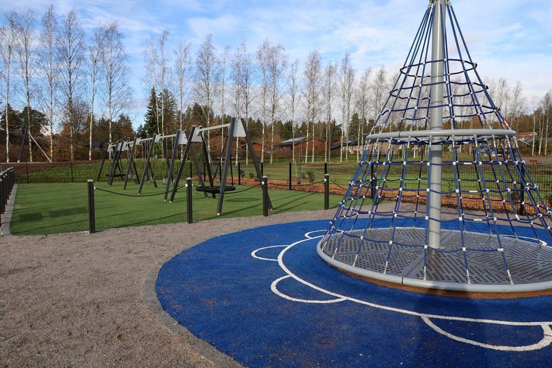 Karuselli-kiipeilyteline jonka alla sininen turvamatto.