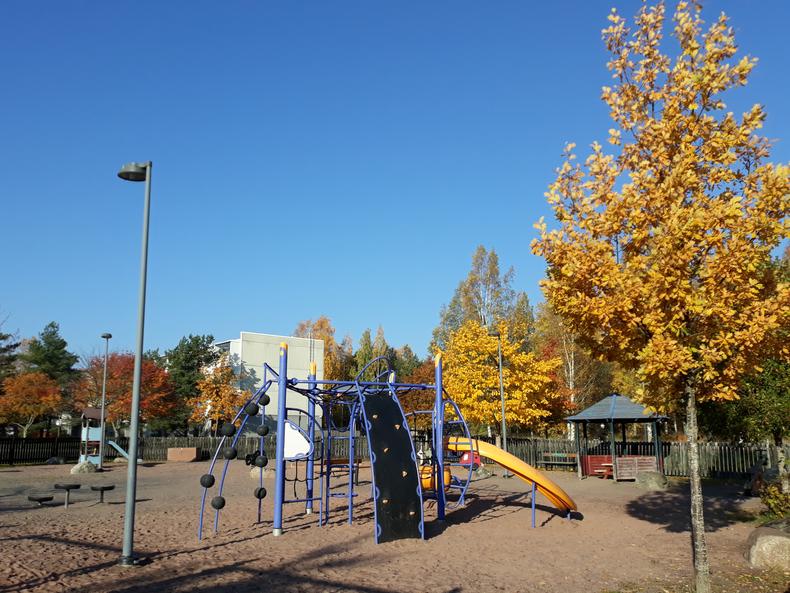 Leikkivälinenitä ja keltalehtisiä puita.