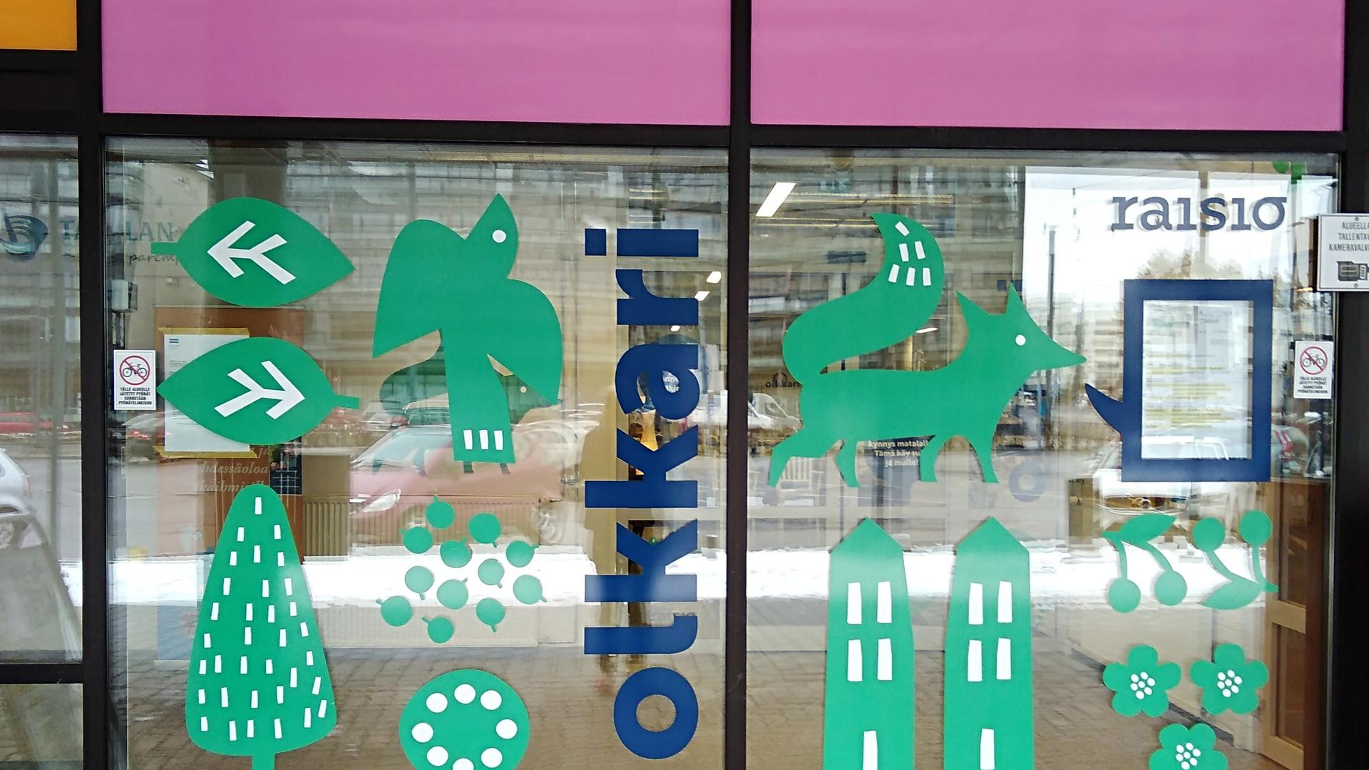 Olkkarin ikkuna, jossa vihreitä kuvioita ja sininen teksti olkkari