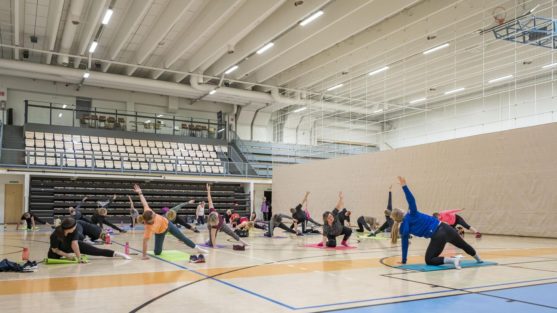 Aikuisia jumppasalissa tekemässä kehonhuoltoa