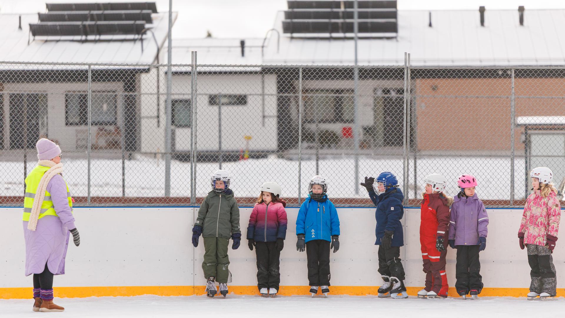 Ihalan koululaiset luistelemassa opettajan kanssa