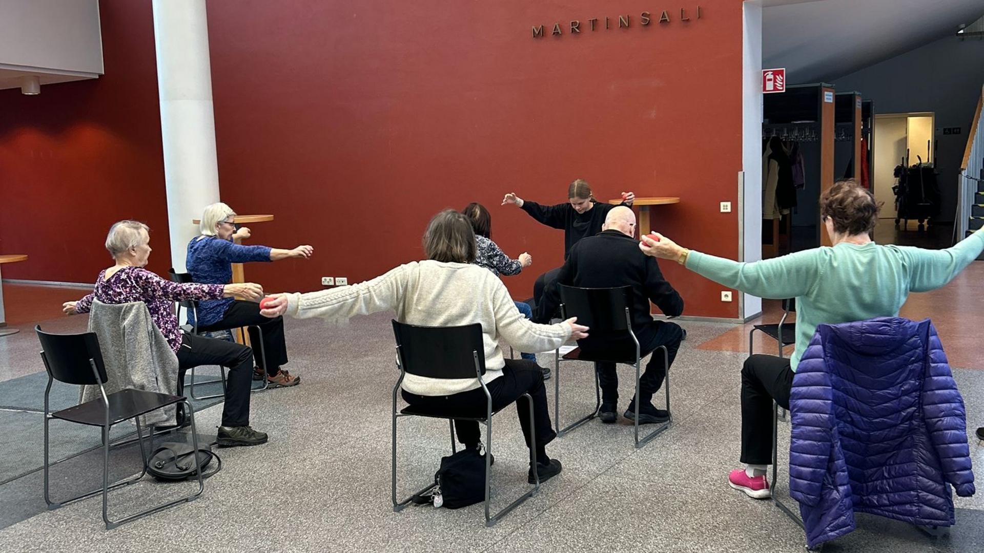 Joukko ihmisiä tuolijumpassa.