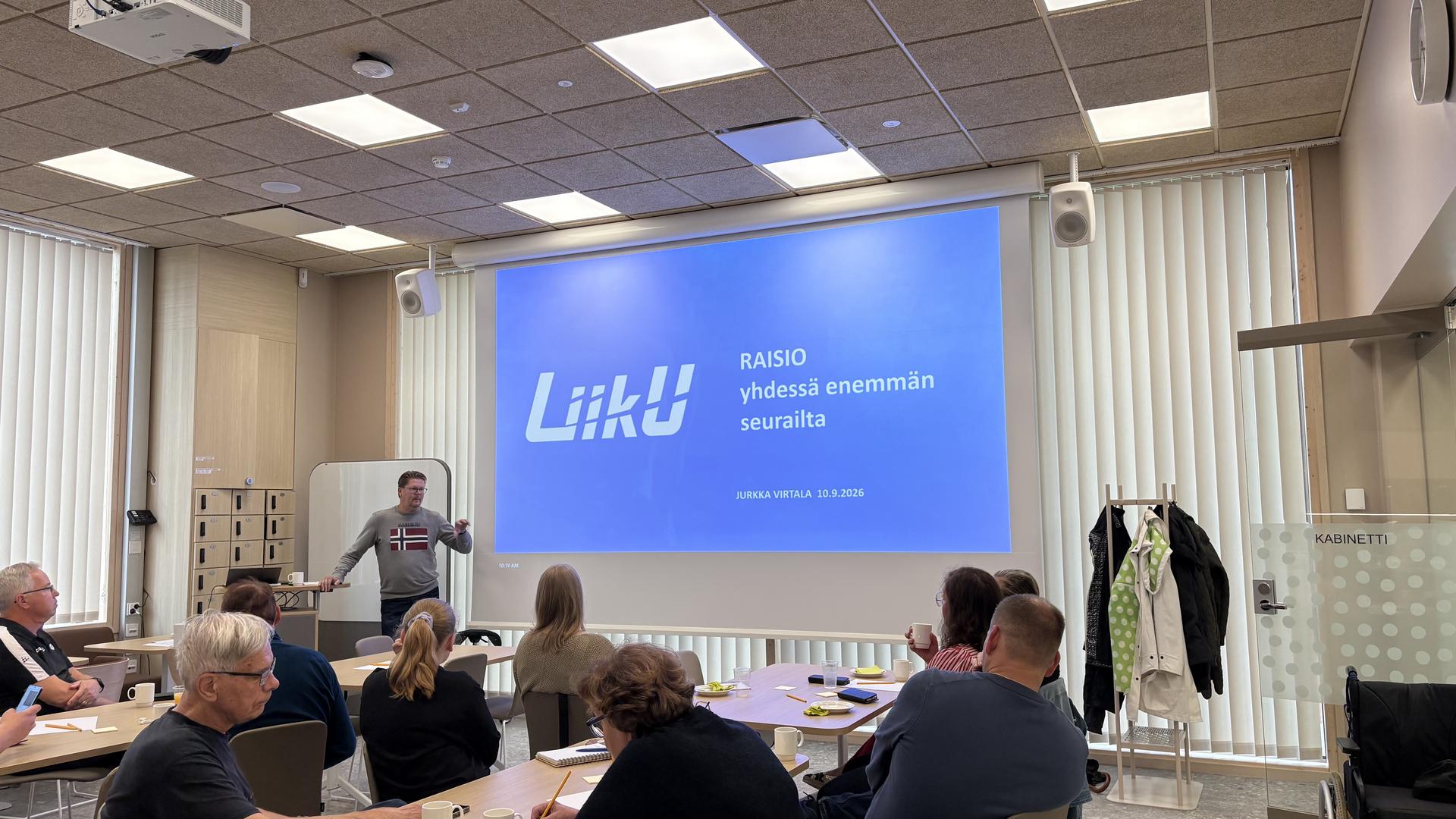 Henkilö esittelee diaesitystä.
