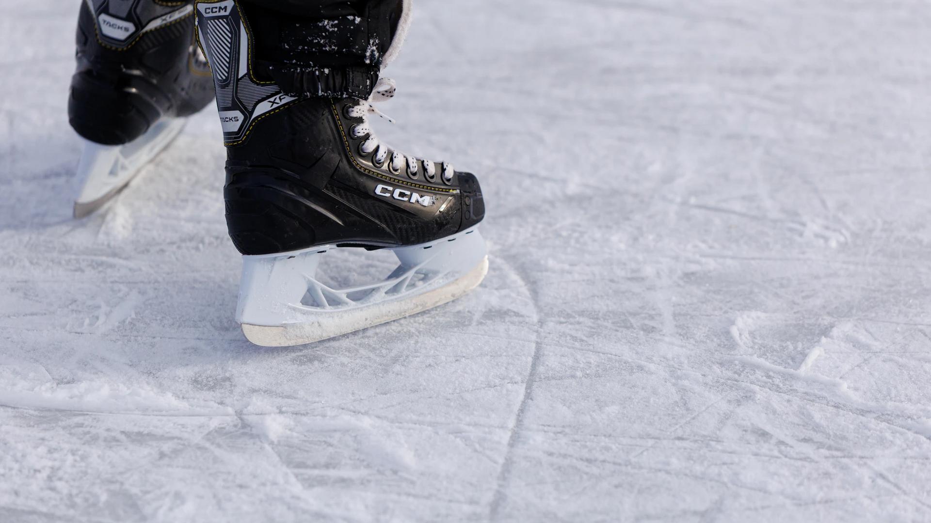 Lapsi luistelee hokkareilla ulkojäällä.