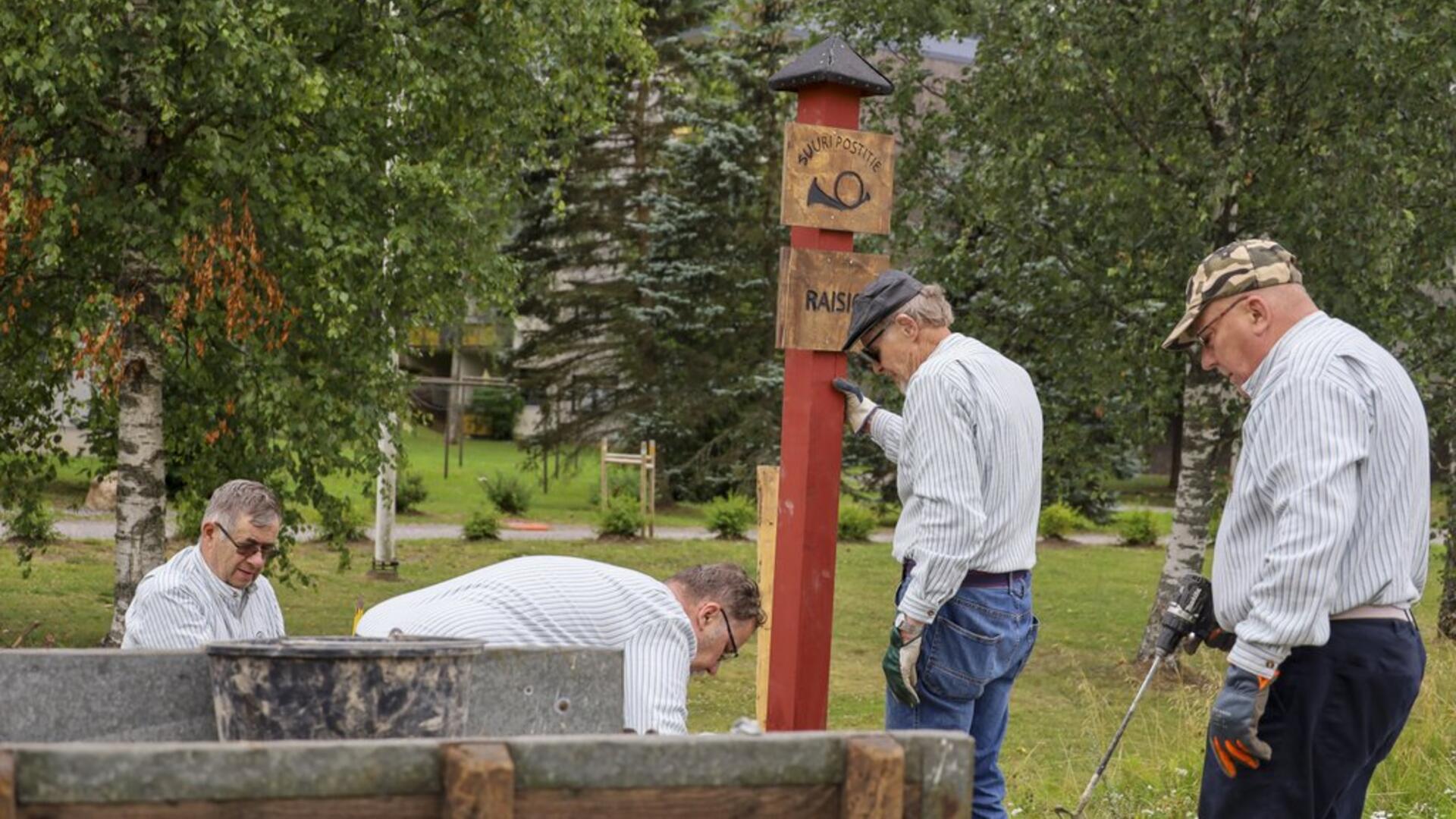 Raisio-Seuran neljä jäsentä pystyttämässä Vanha Postitie-merkkiä