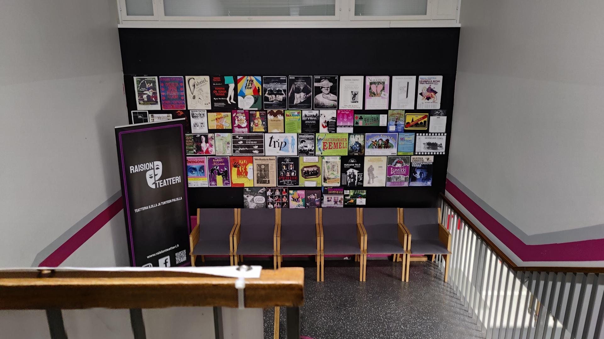 Kuva Raision teatterin portaikosta. Seinällä on esitysten julisteita.