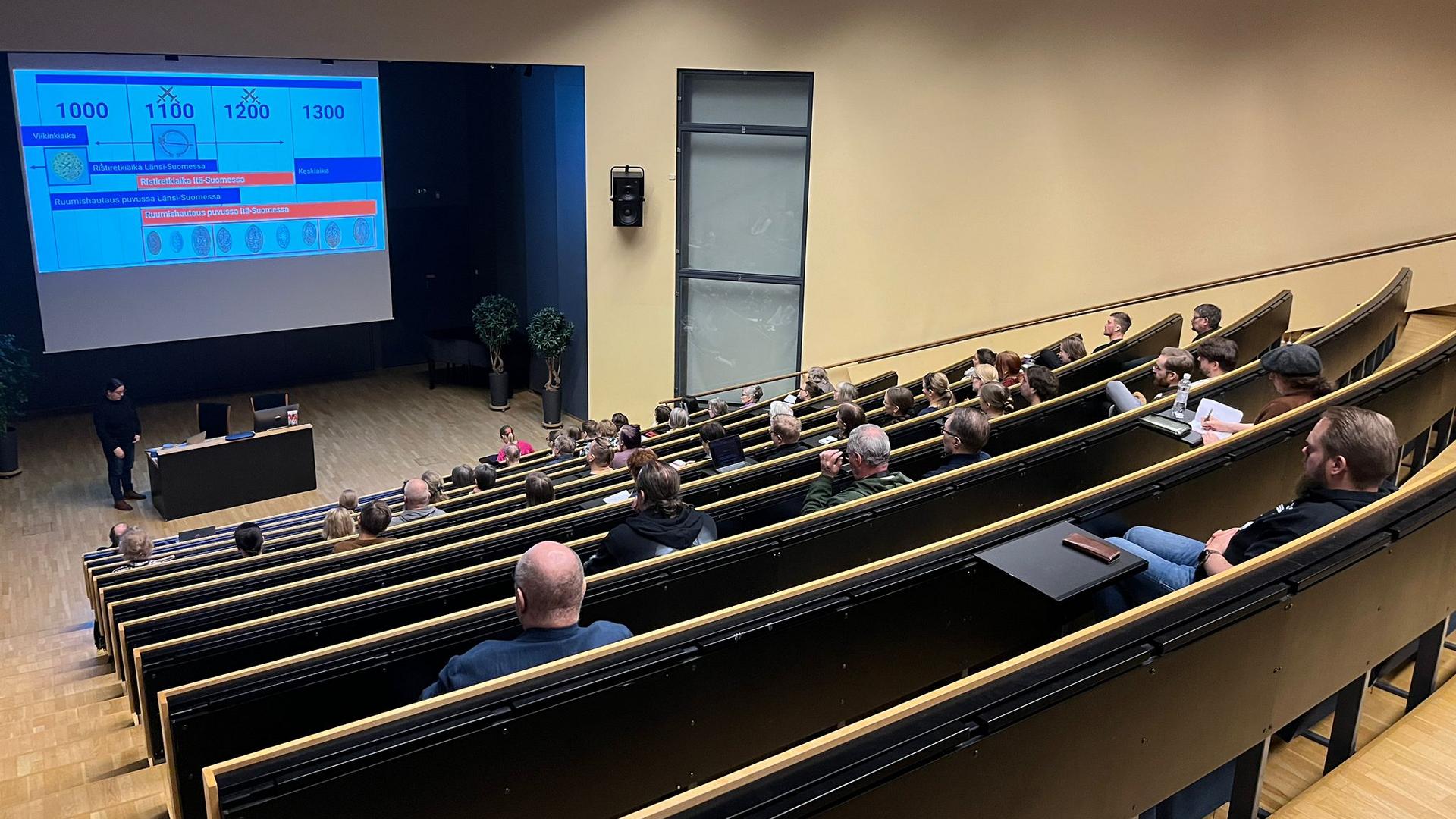 Ihmisiä auditoriotilassa