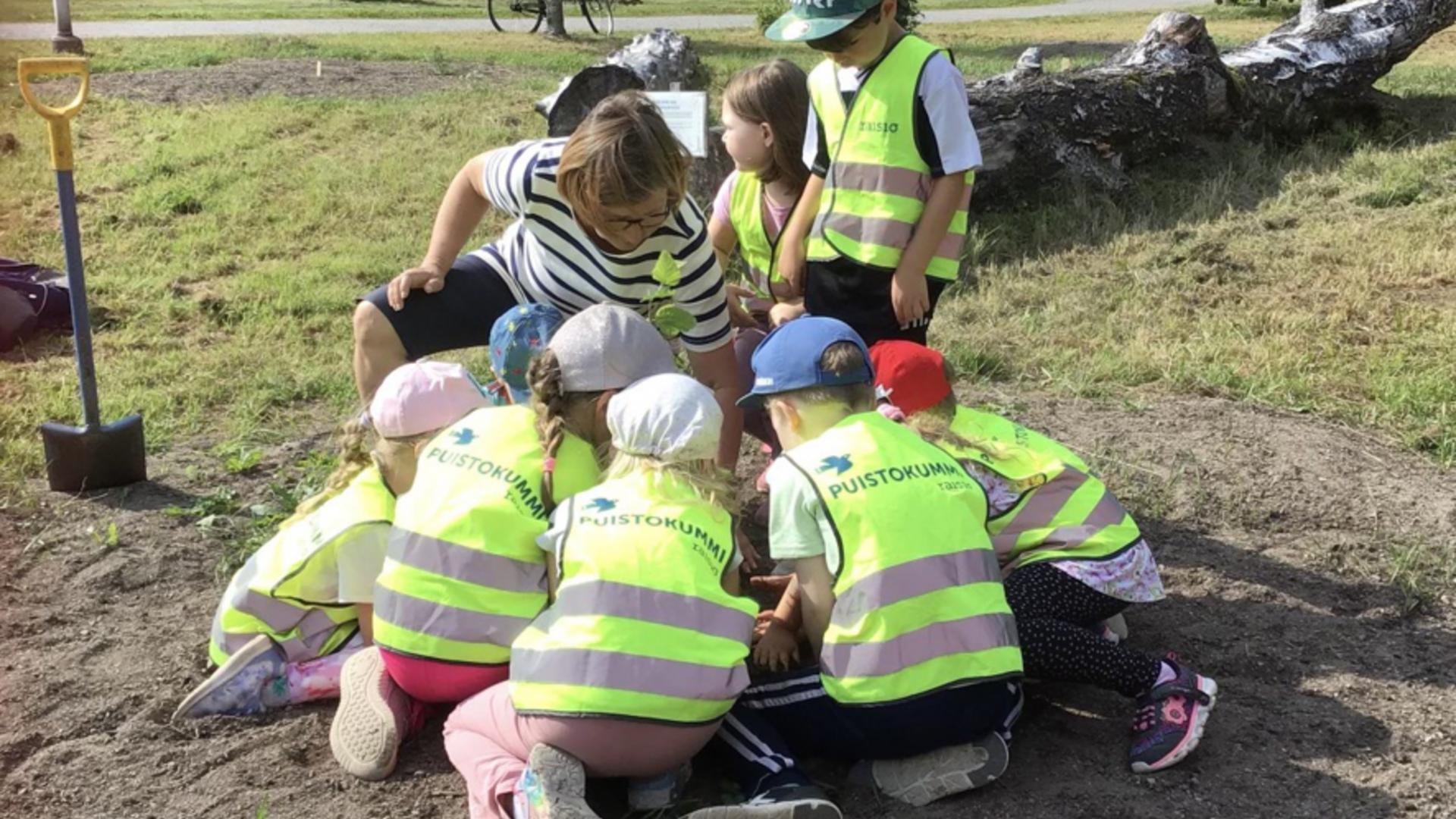 Konsan esiopetus ja puistokummit istuttamssa puuta