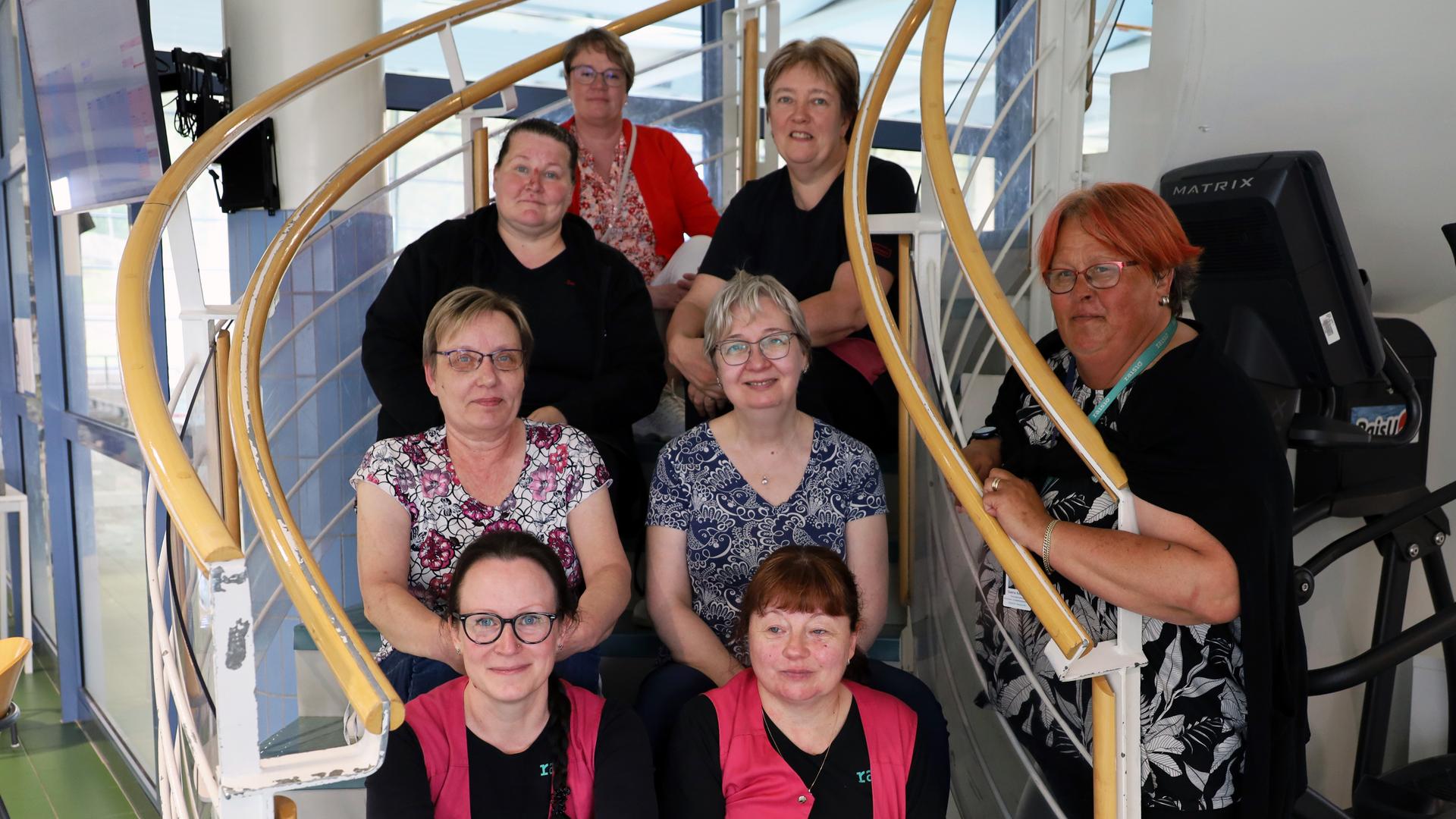 Ulpukan siivoojat istuvat Ulpukan portailla yhdessä Liikunta- ja nuorisotoimen johtajan ja siivoustyönjohtajan kanssa.