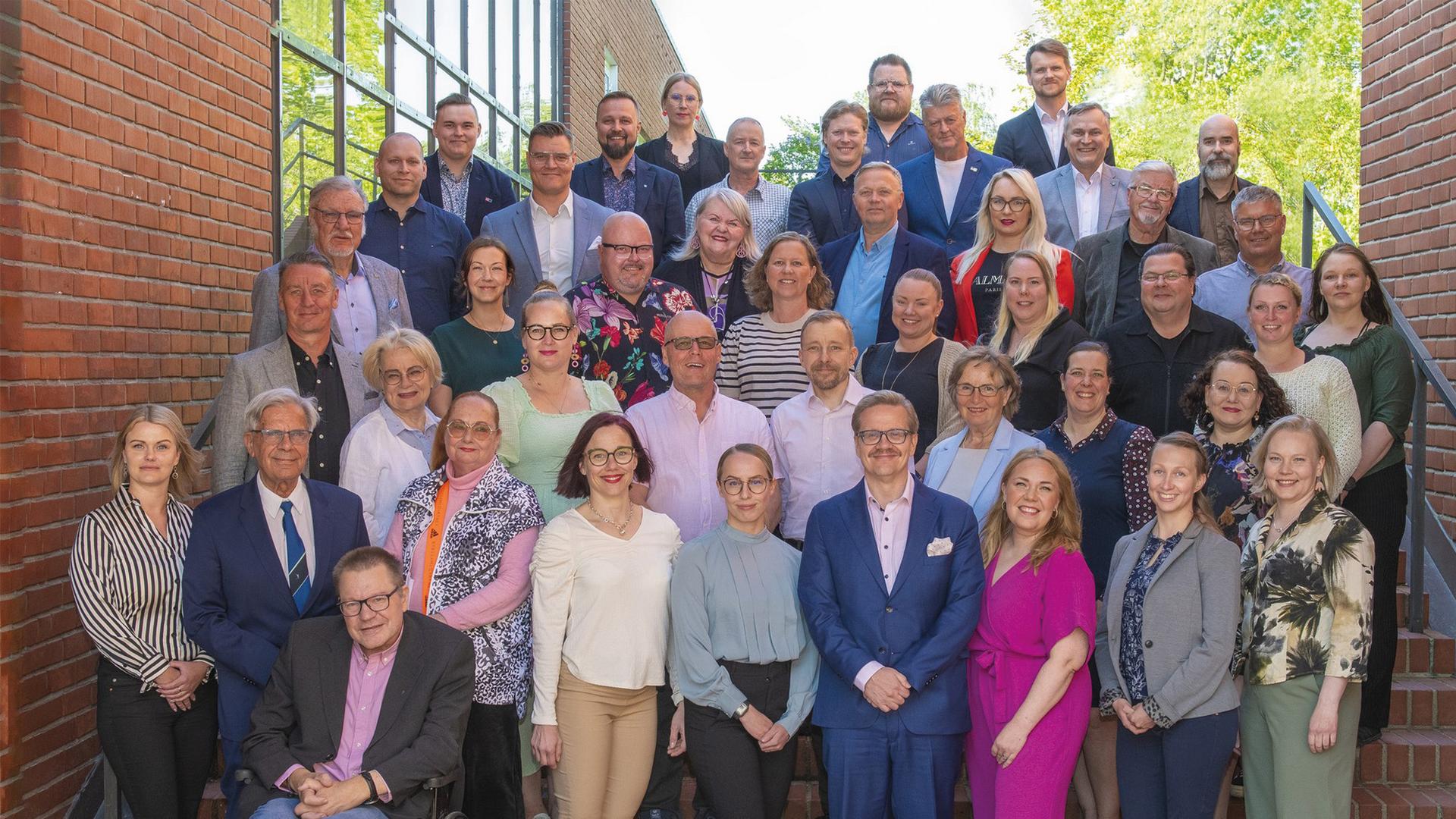 Kaupunginvaltuutetut ryhmäkuvassa kaupungintalon edustalla. 