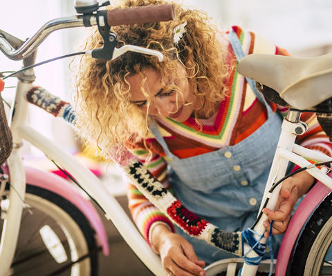 nuori nainen koristelee polkupyöräänsä käsitöille