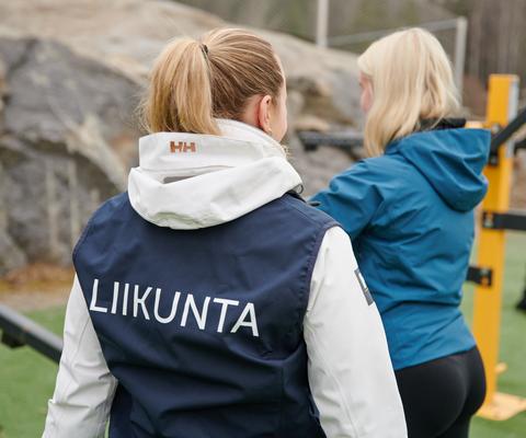 Liikuntaneuvoja ohjaa henkilöä ulkona.