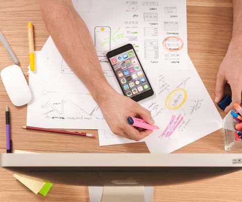 Ihminen piirtää paperille suunnitelmia