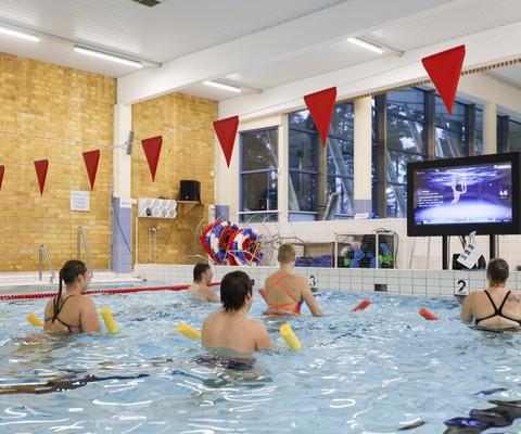 Ryhmä vesijumppareita osallistuu virtuaalijumppaan Ulpukassa.