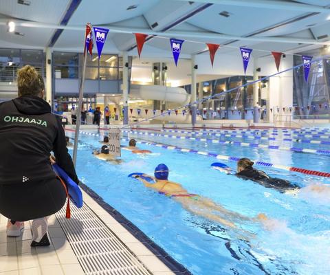Ohjaaja valvoo uimareita Ulpukan uimahallissa.