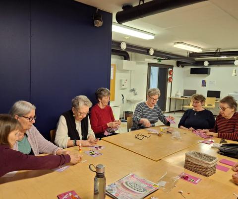 Jouko eläkeläisnaisia askartelemassa pöydän ääressä.