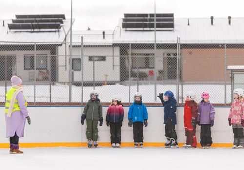 Ihalan koululaiset luistelemassa opettajan kanssa