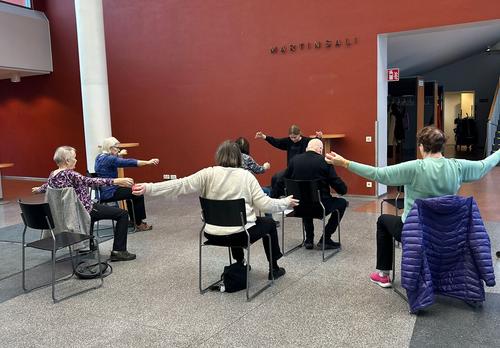 Joukko ihmisiä tuolijumpassa.