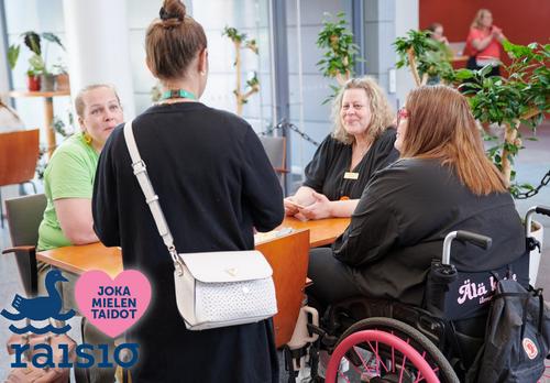 JokaMielentaidot-tapahtuman osallistujia pöydän ympärillä.