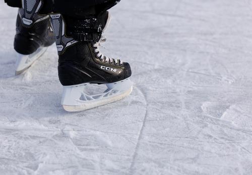 Lapsi luistelee hokkareilla ulkojäällä.