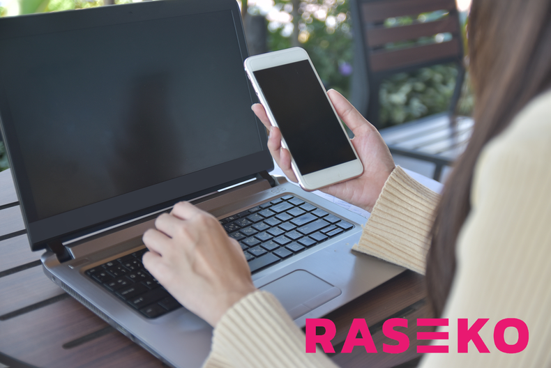 Naishahmon edessä läppäri sekä kädessään älypuhelin. Oikeassa alareunassa pinkkinen logo, jossa lukee Raseko.