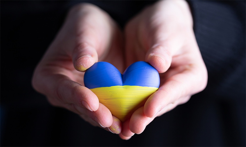 Kädet ojentavat Ukrainan lipun väristä sydäntä.